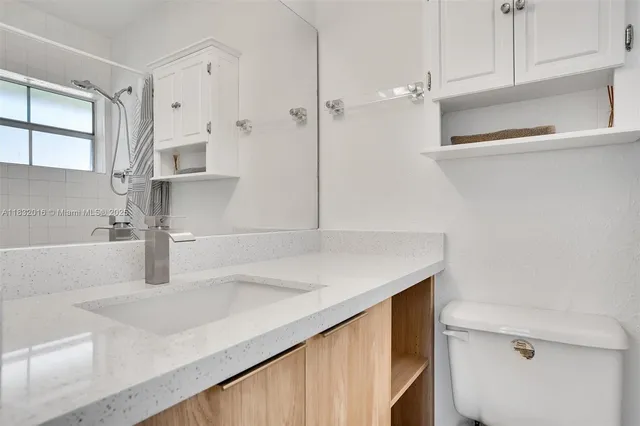 a kitchen with a sink a refrigerator and cabinets