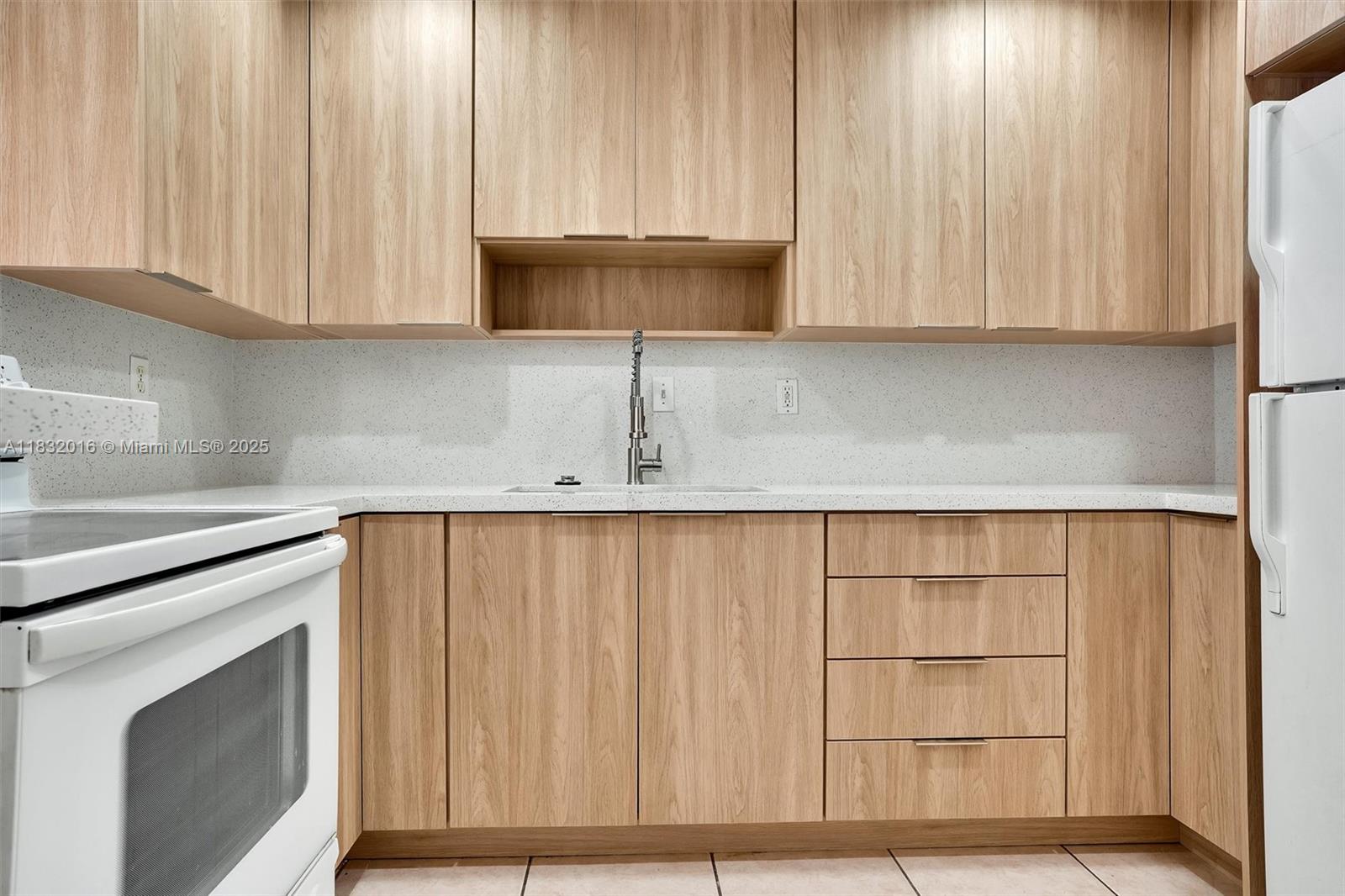 8650 Southwest 67th Avenue, Unit 1025 Pinecrest, FL 33156 - Photo 5 of 26 a kitchen with a sink cabinets and a microwave oven