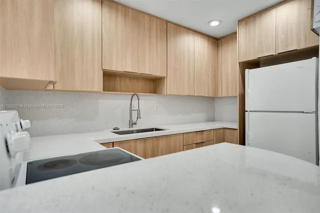 a kitchen with a refrigerator and a sink