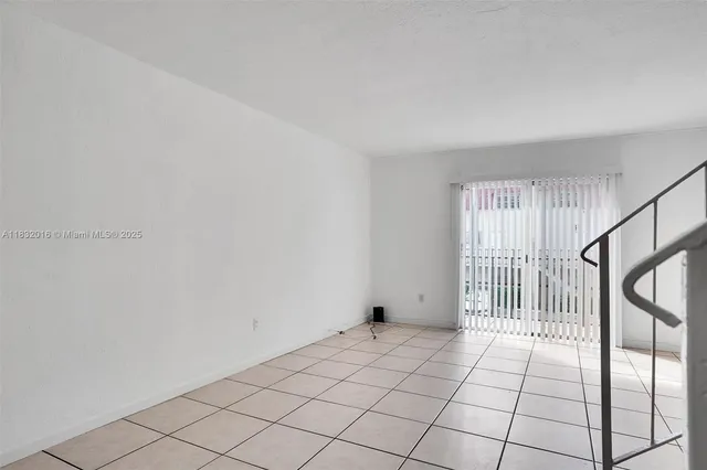 a view of an empty room and staircase