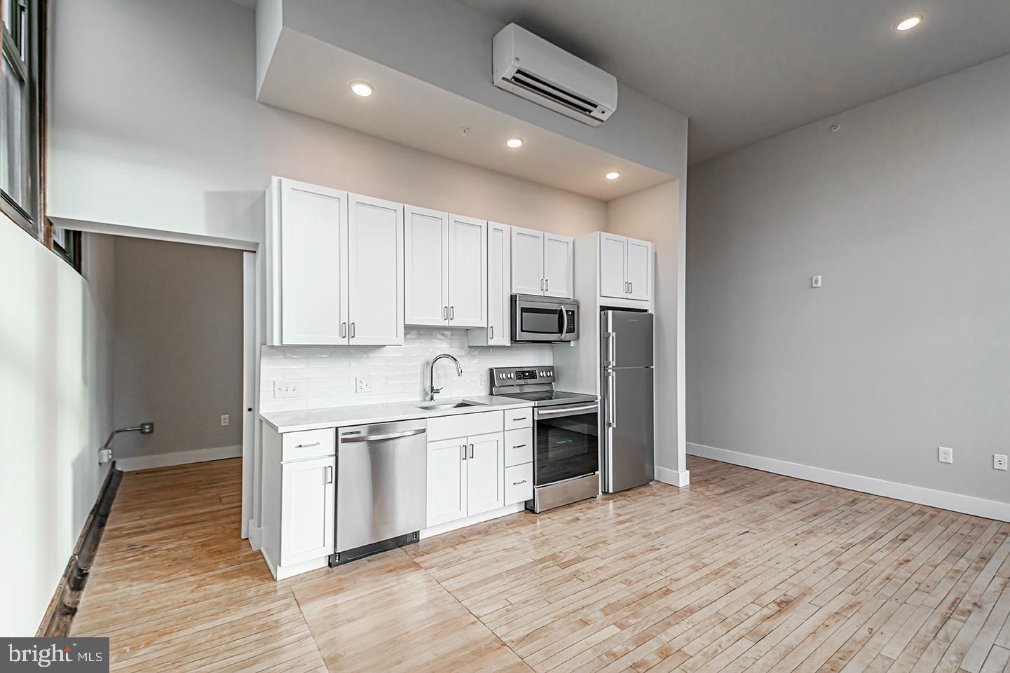 1300 South 19th Street, Unit 316 Philadelphia, PA 19146 - Photo 2 of 19 a kitchen with stainless steel appliances granite countertop a refrigerator and a stove top oven