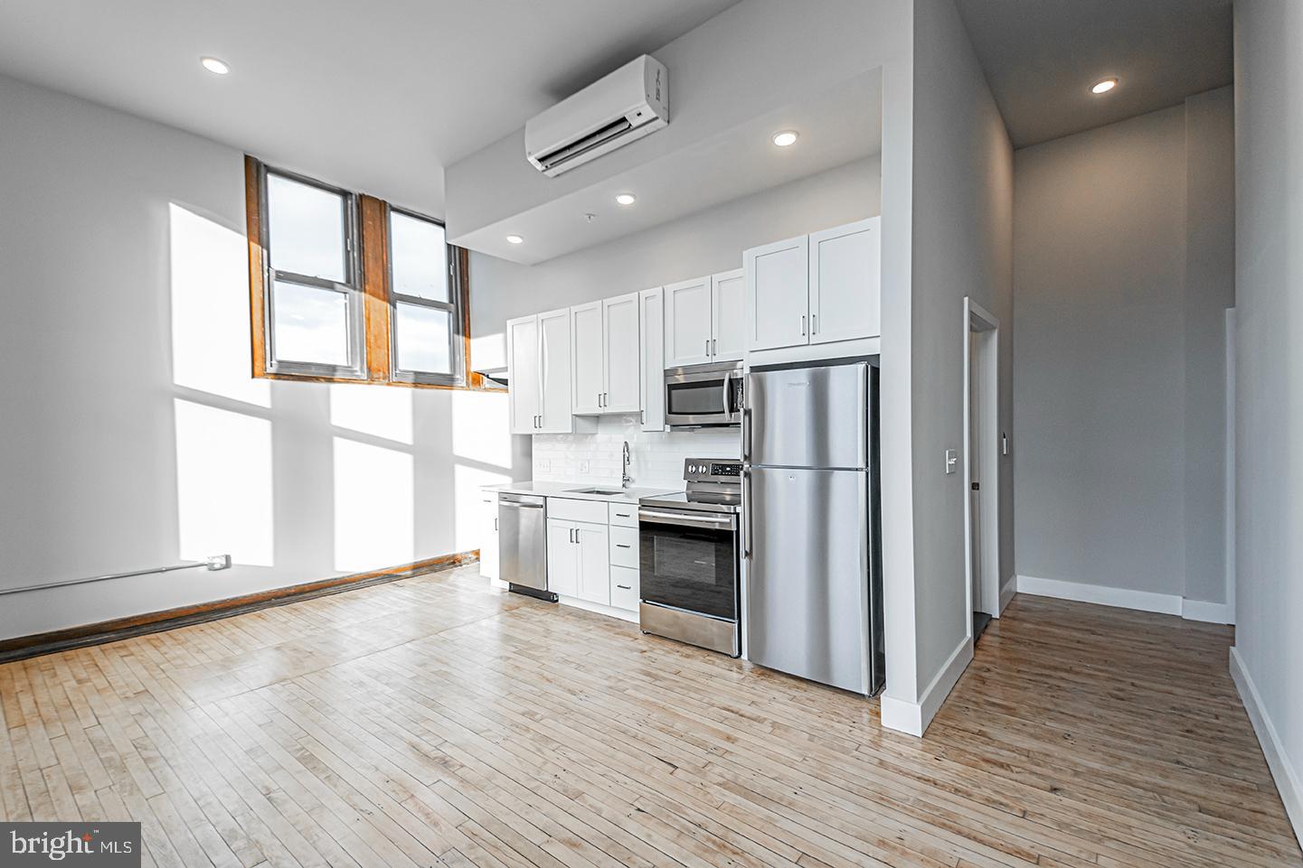 1300 South 19th Street, Unit 316 Philadelphia, PA 19146 - Photo 7 of 19 a kitchen with stainless steel appliances a refrigerator a stove top oven and kitchen island