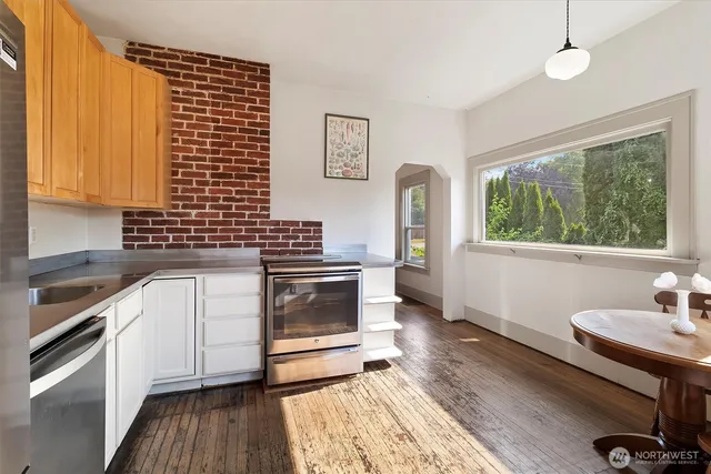 a kitchen with granite countertop a stove a sink and wooden floor