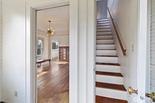 a view of a hallway with wooden floor and staircase