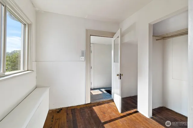 a view of a bedroom with wooden floor and a bathroom