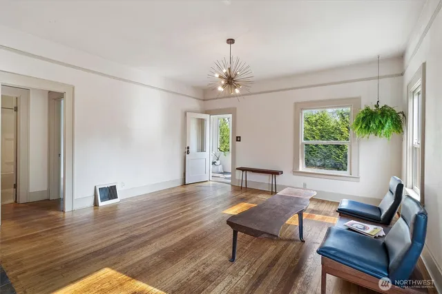 a living room with furniture a window and wooden floor