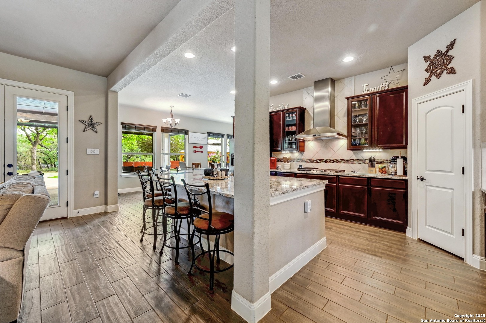 101 La Rosa Drive Blanco, TX 78606 - Photo 5 of 31 a kitchen with stainless steel appliances kitchen island granite countertop a stove a refrigerator a microwave a dining table and chairs with wooden floor