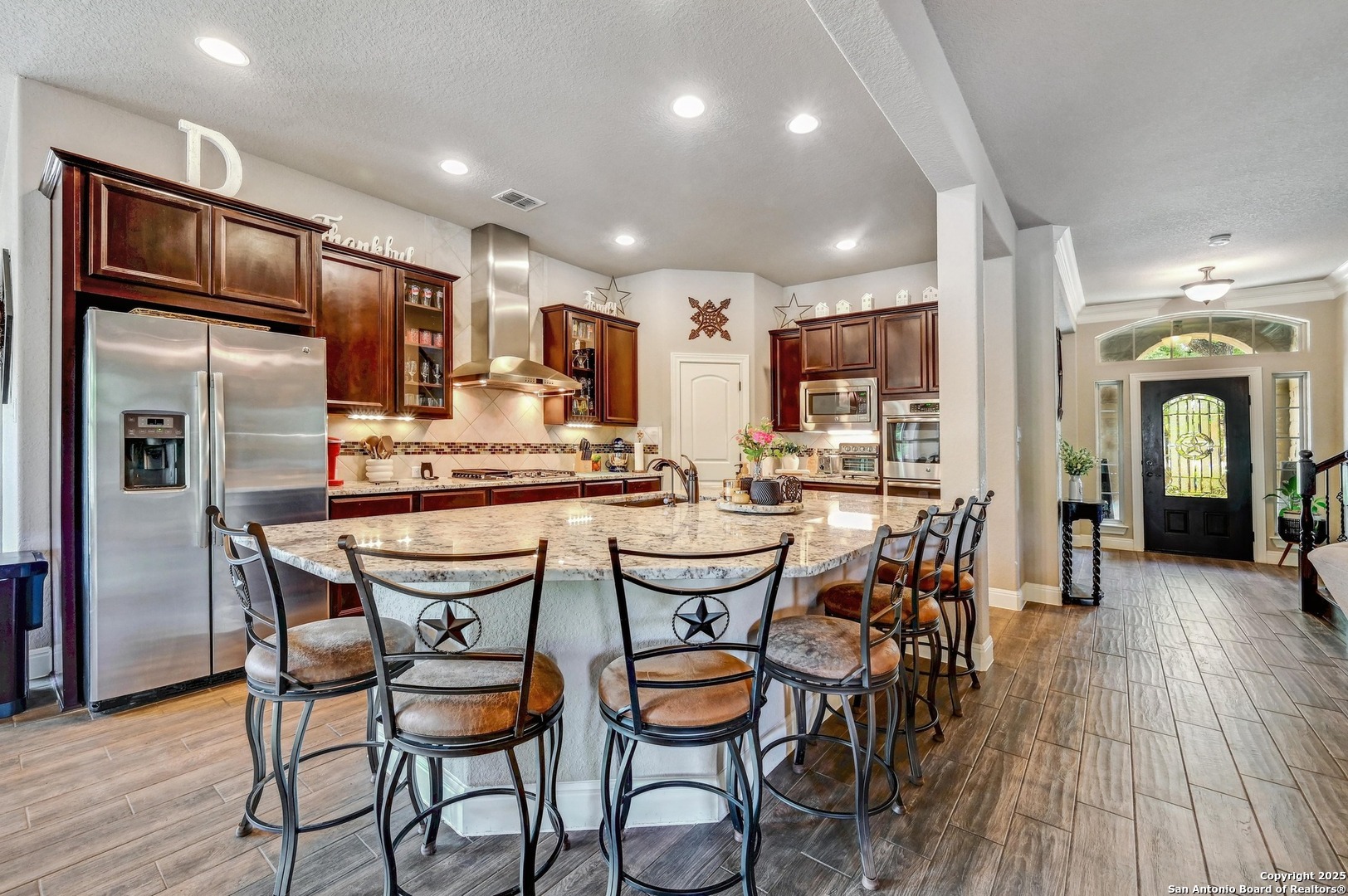 101 La Rosa Drive Blanco, TX 78606 - Photo 7 of 31 a kitchen with stainless steel appliances kitchen island granite countertop a dining table chairs refrigerator and sink