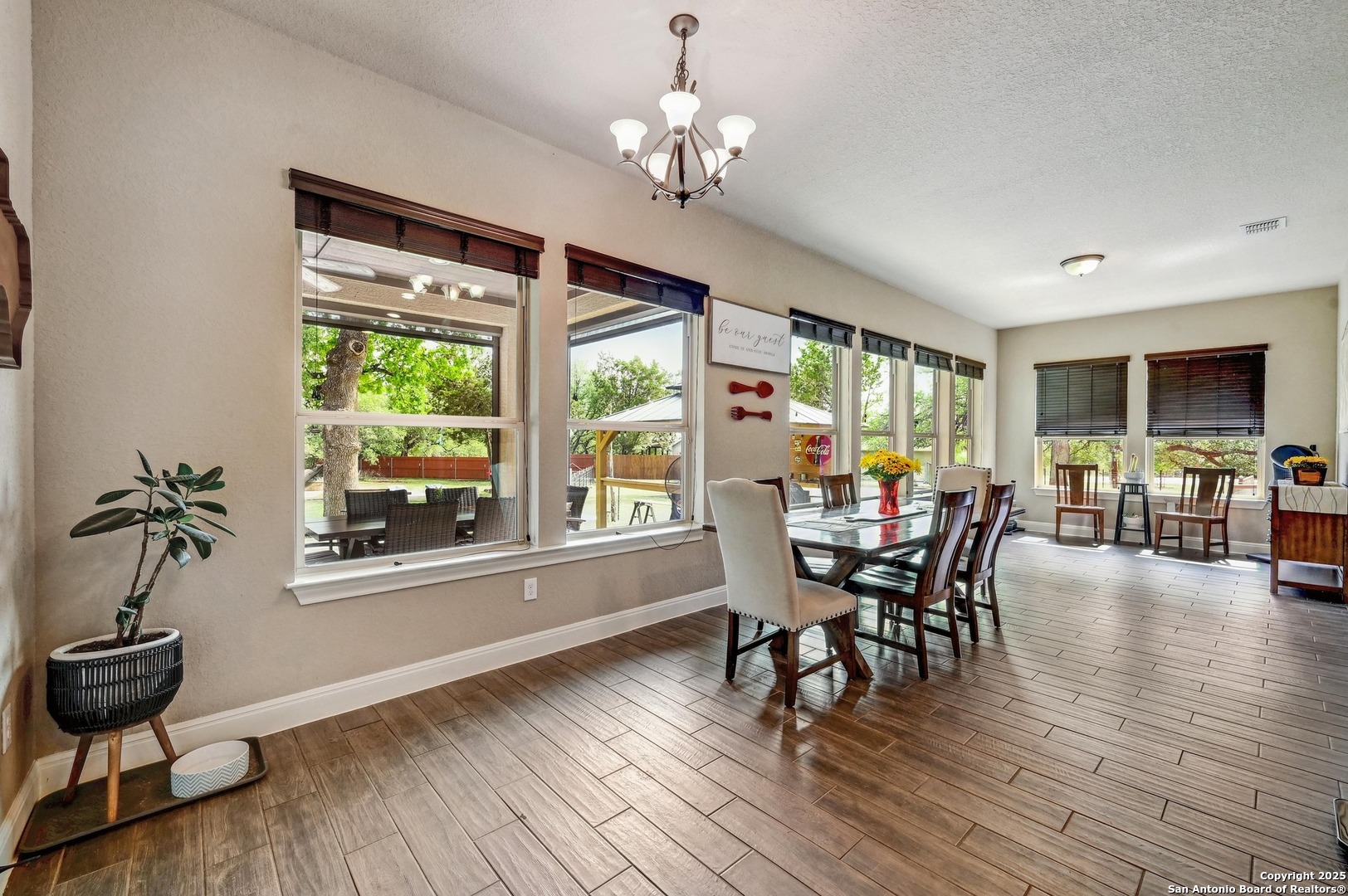 101 La Rosa Drive Blanco, TX 78606 - Photo 9 of 31 a dining room with wooden floor a chandelier a glass table and chairs