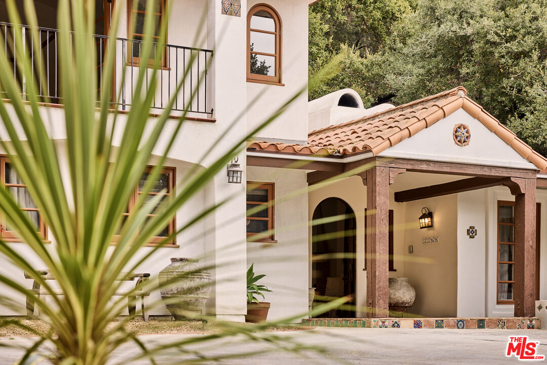 a front view of a house with a tree