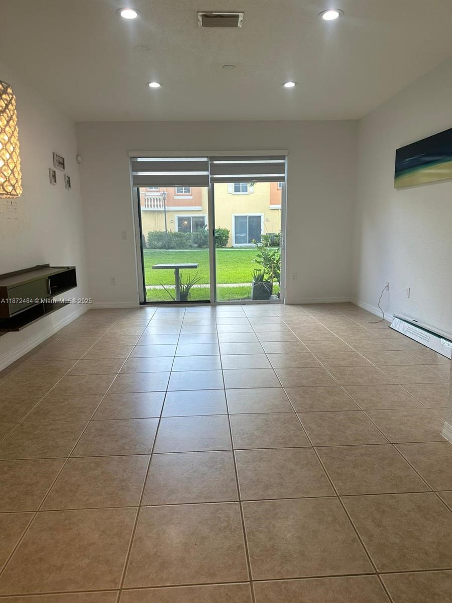 8936 Southwest 18th Street, Unit 8936 Miramar, FL 33025 - Photo 3 of 10 a view of an empty room with a fireplace and a floor to ceiling window