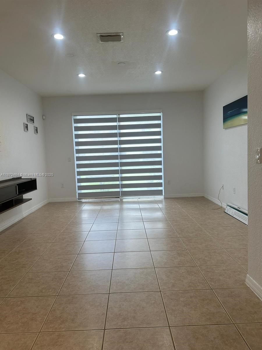 8936 Southwest 18th Street, Unit 8936 Miramar, FL 33025 - Photo 4 of 10 a view of an empty room with a window