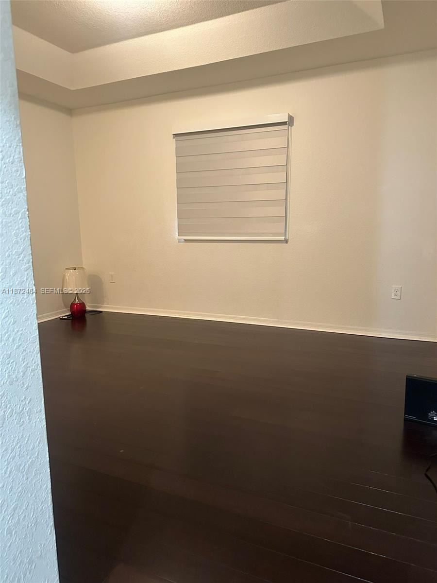 8936 Southwest 18th Street, Unit 8936 Miramar, FL 33025 - Photo 8 of 10 an empty room with wooden floor and windows