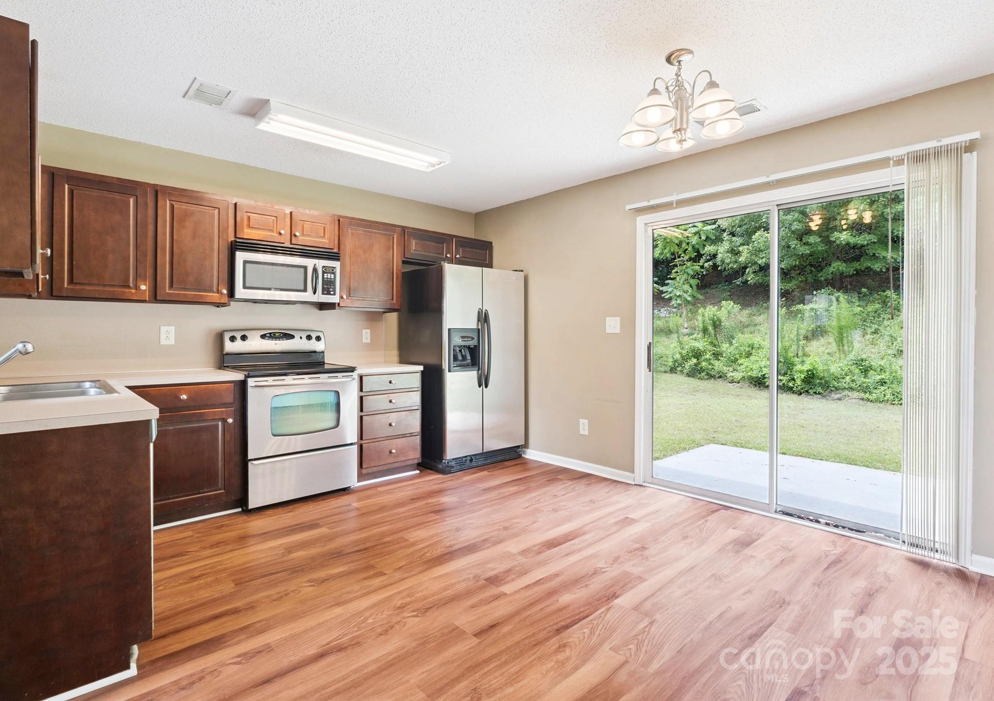829 Raindrops Road Gastonia, NC 28054 - Photo 1 of 16 a kitchen with stainless steel appliances granite countertop a stove a sink dishwasher and a refrigerator with wooden floor
