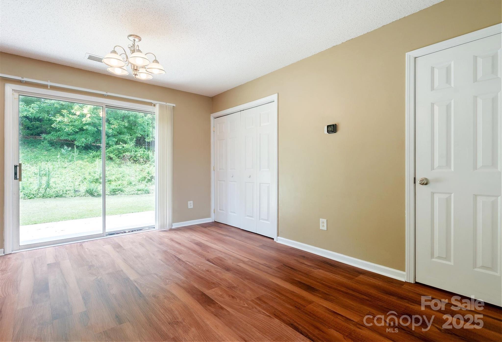 829 Raindrops Road Gastonia, NC 28054 - Photo 3 of 16 a view of an empty room with wooden floor and a window