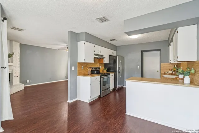a kitchen with stainless steel appliances a refrigerator and a stove top oven