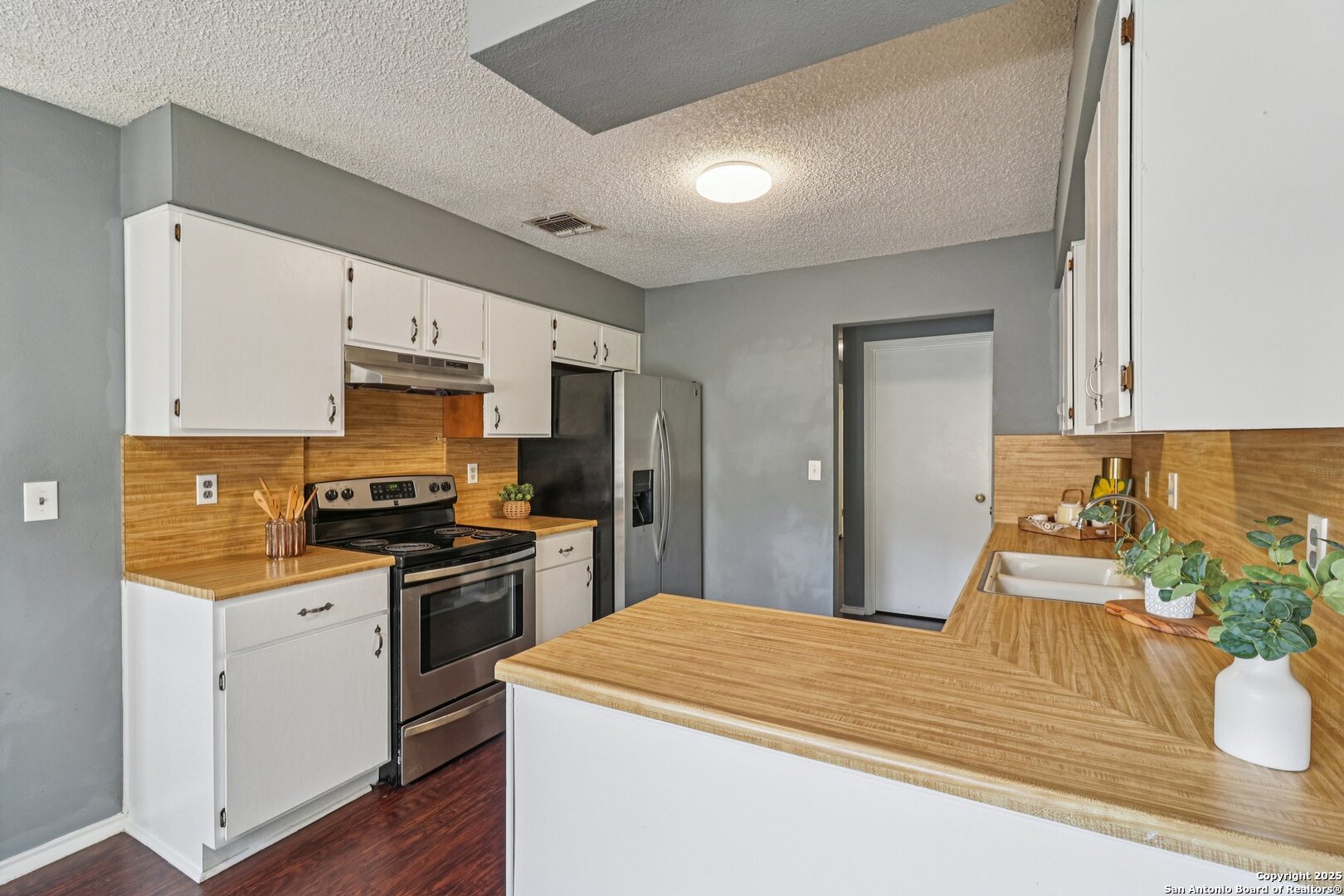 9334 Dover Ridge San Antonio, TX 78250 - Photo 20 of 39 a kitchen with stainless steel appliances kitchen island granite countertop a stove a sink and white cabinets