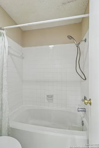 a bathroom with a bath tub with a shower