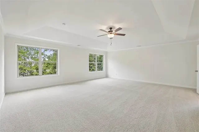 an empty room with windows and ceiling fan view