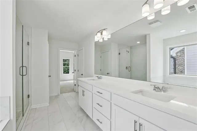 a spacious bathroom with a double vanity sink mirror and a bathtub