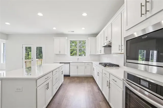 a kitchen with white cabinets stove and sink