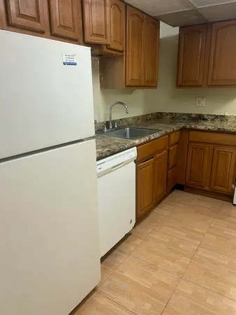 a kitchen with stainless steel appliances granite countertop a refrigerator a stove a sink and dishwasher