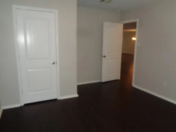 an empty room with wooden floor and closet