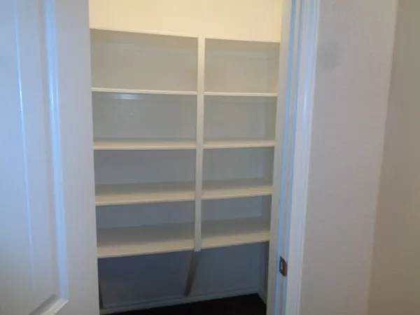a view of walk in closet with empty racks