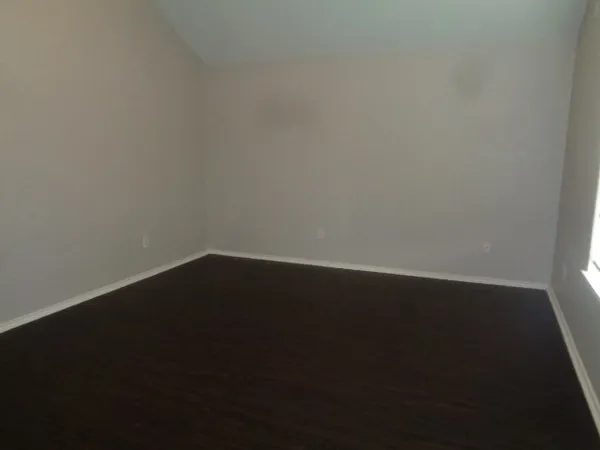 a view of a small space with wooden floor and a window