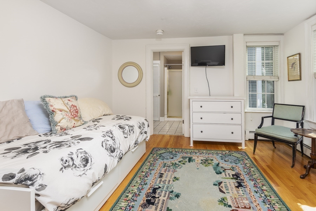 10 Andrew Street, Unit 2A Salem, MA 01970 - Photo 19 of 27 a bedroom with a bed and flat screen tv