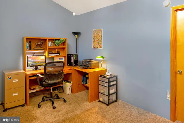 a view of a workspace with furniture and a window