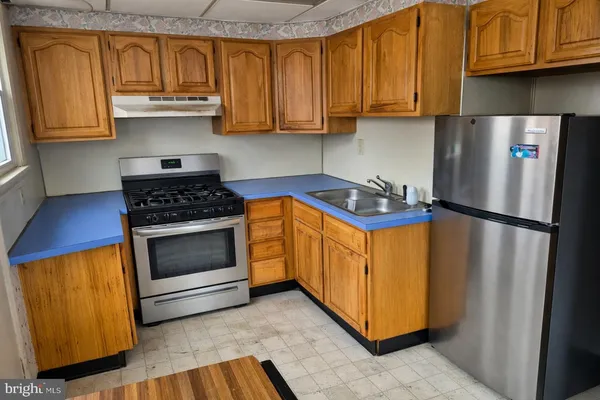a kitchen with stainless steel appliances granite countertop a refrigerator a stove a sink and dishwasher