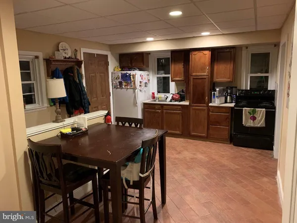 a kitchen with stainless steel appliances kitchen island granite countertop a table chairs microwave and sink