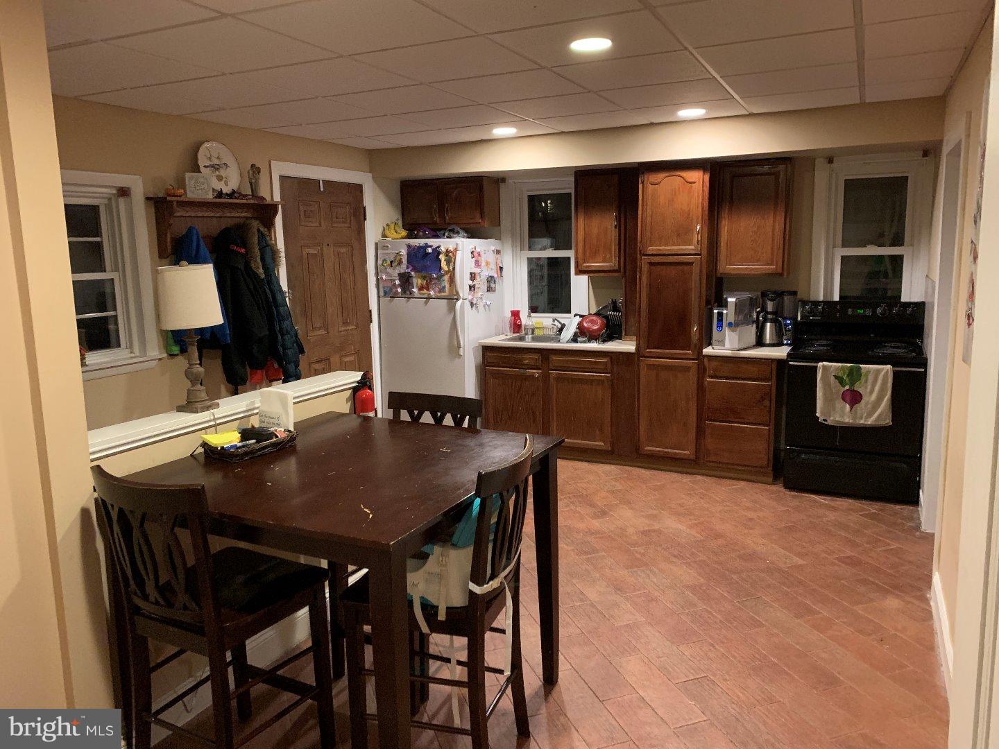 555 Chestnut Street, Unit REAR West Reading, PA 19611 - Photo 2 of 11 a kitchen with stainless steel appliances kitchen island granite countertop a table chairs microwave and sink