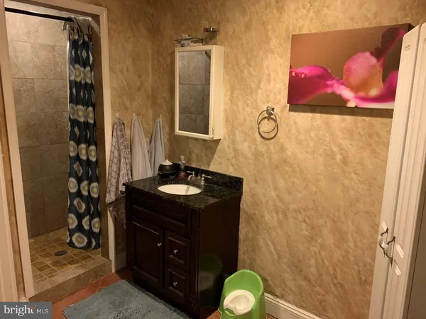 a bathroom with a granite countertop sink toilet and shower
