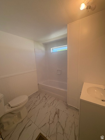 1111 North 2000 West, Unit 293 Farr West, UT 84404 - Photo 11 of 13 Bathroom featuring white and gray veined tile flooring, a white vanity with an integrated sink, a white toilet, and a white bathtub with a built-in soap dish