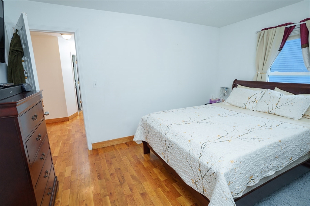 80 Collins Street Lynn, MA 01902 - Photo 15 of 25 a bedroom with a bed and a flat tv screen on a dresser