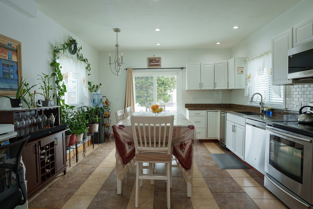 80 Collins Street Lynn, MA 01902 - Photo 9 of 25 a kitchen with stainless steel appliances kitchen island granite countertop a stove a sink and a microwave