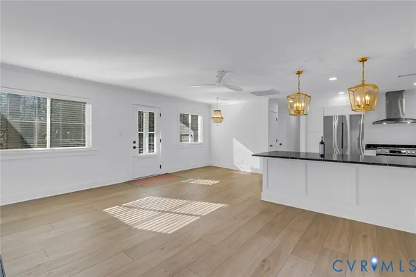 a kitchen with stainless steel appliances wooden floor and a refrigerator