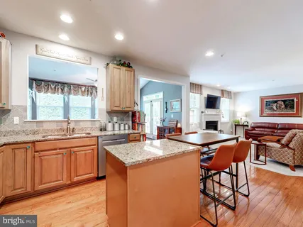 a open kitchen with stainless steel appliances granite countertop a sink and dishwasher a stove with wooden floor