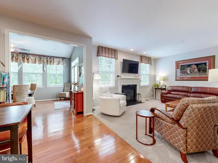 a living room with fireplace furniture and a large window