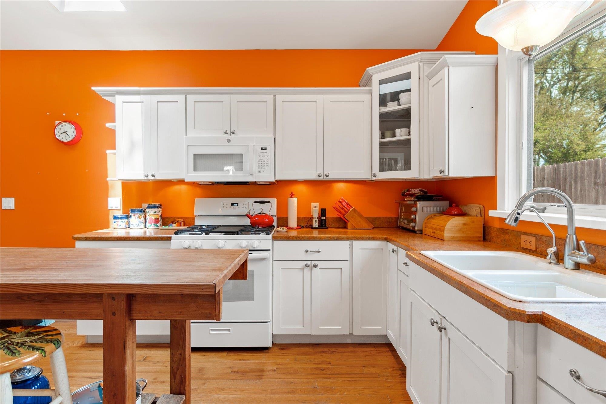 68 Kings Ferry Way St. Augustine, FL 32084 - Photo 13 of 52 Kitchen featuring white appliances, white cabinetry, glass front cabinets, and light wood flooring