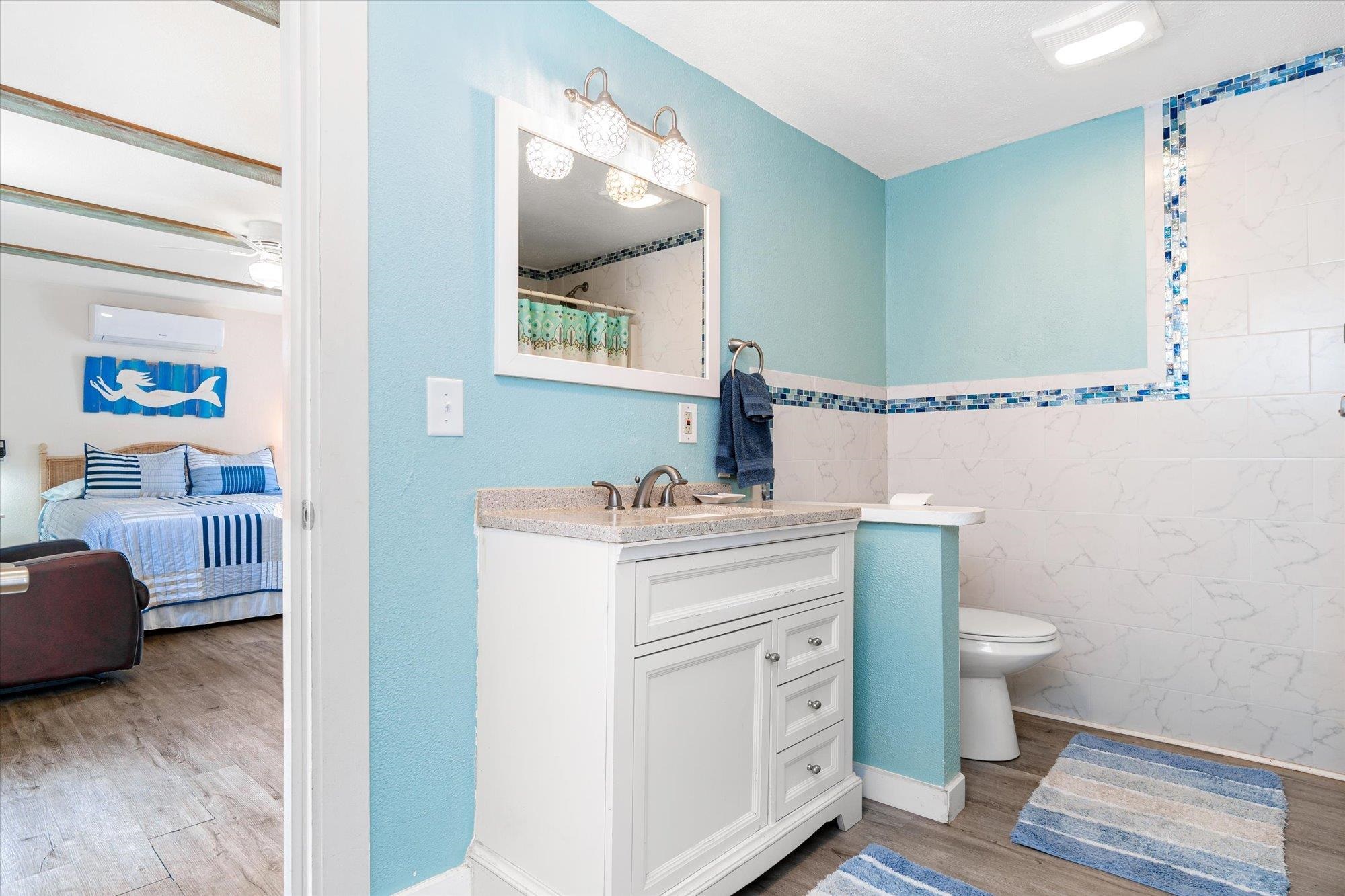 68 Kings Ferry Way St. Augustine, FL 32084 - Photo 42 of 52 Ensuite bathroom featuring light wood-style flooring, vanity, a shower with shower curtain, and tile walls