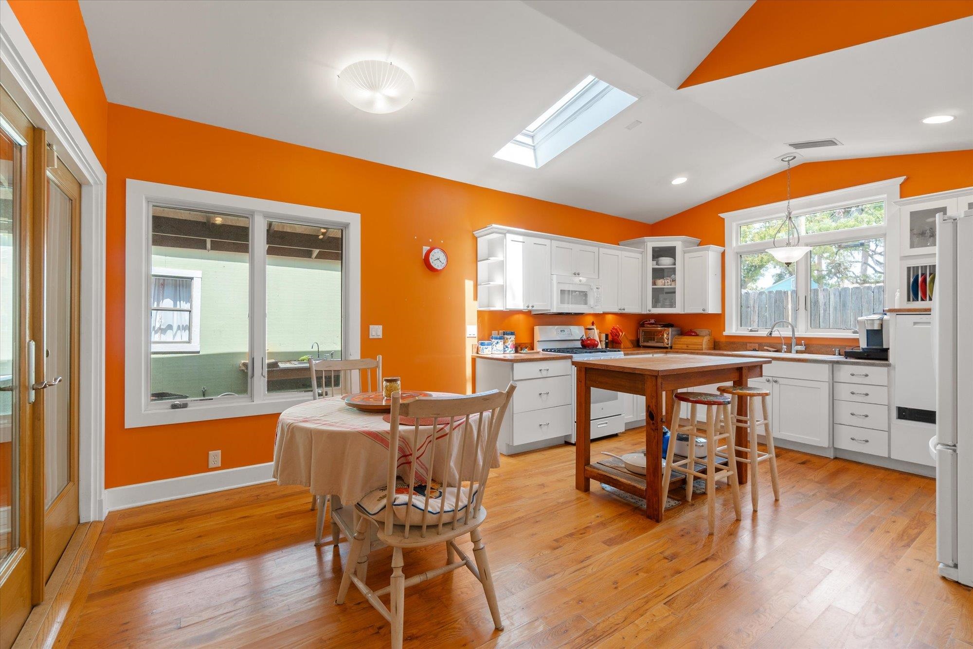 68 Kings Ferry Way St. Augustine, FL 32084 - Photo 10 of 52 Kitchen with white cabinets, a skylight, glass front cabinets, white appliances, and lofted ceiling