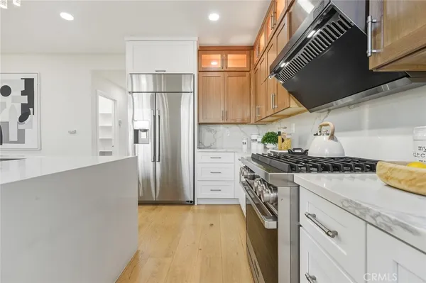 a kitchen with a stove a refrigerator and cabinets