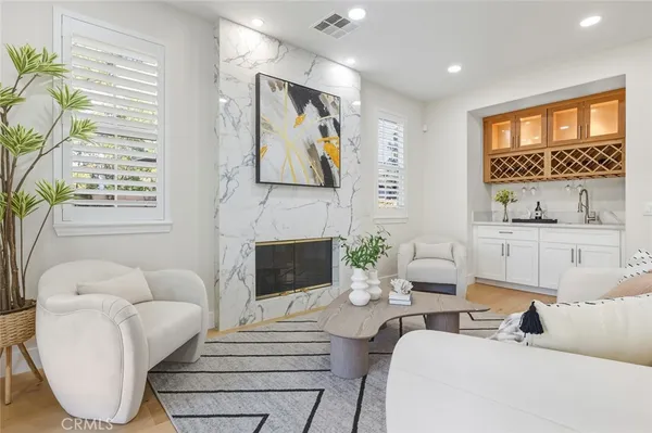 a living room with furniture a fireplace and a large window