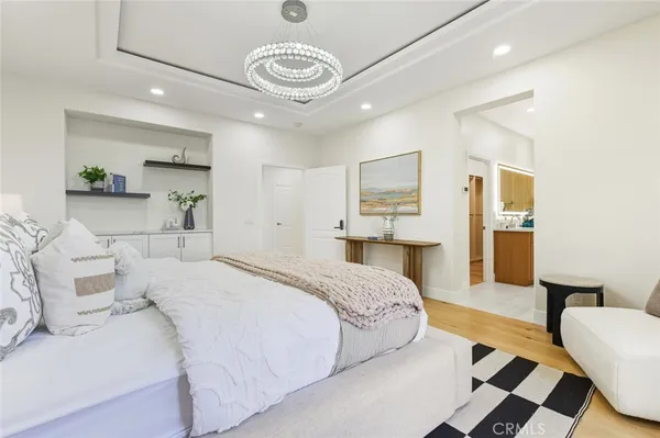a spacious bedroom with a bed and a chandelier