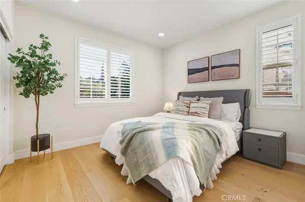 a bedroom with a bed and a potted plant