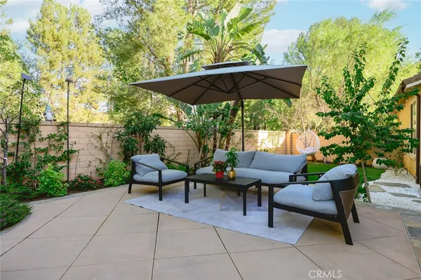 a view of backyard with outdoor seating and trees