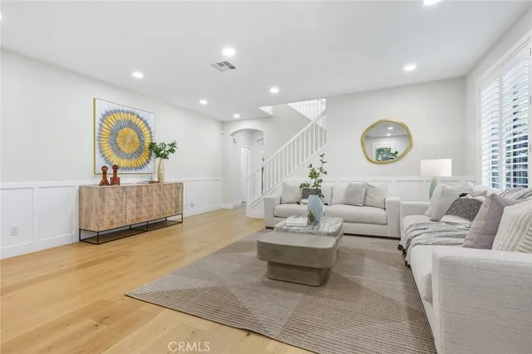 a living room with furniture a rug and wall paintings